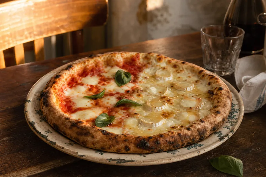 Pizza moitie-moitie tomate et anchois servie Chez Nino.